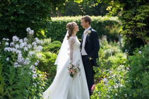 a bride and groom in the gardens of chenies manor house after their wedding